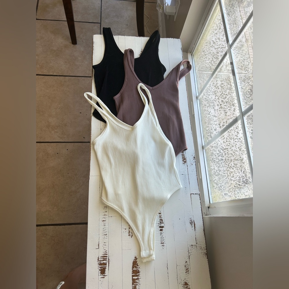 Maroon (purple brownish color), cream and black body suits